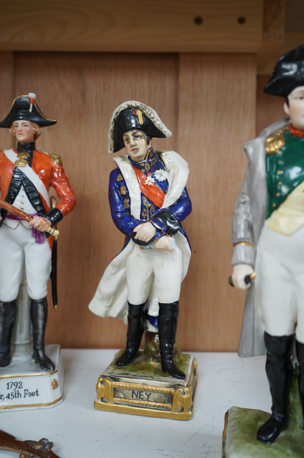 Four Continental porcelain figures wearing military dress including Napoleon and Officer, 45th Foot, largest 23cm high. Condition - good